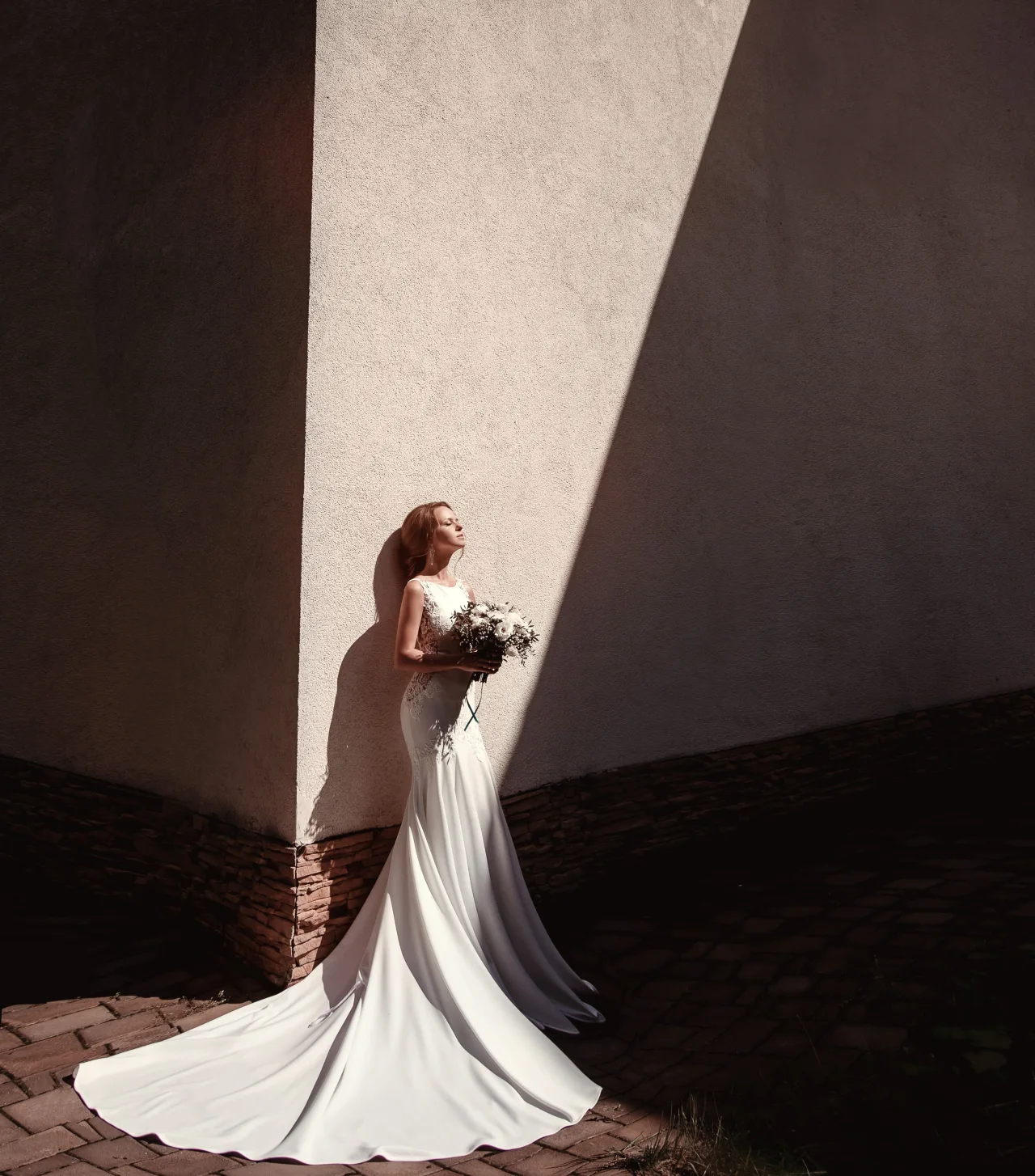Bride standing in dramatic architectural light